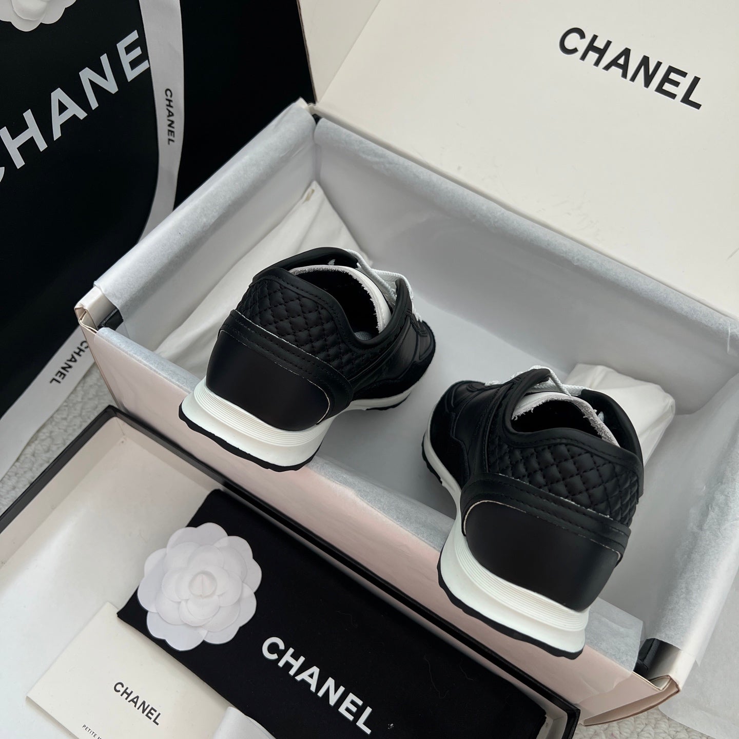 Chanel unisex black leather sneakers with white laces, back view