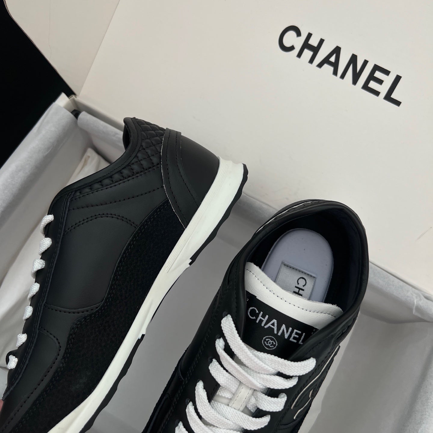 Chanel unisex black leather sneakers with white laces, side profile