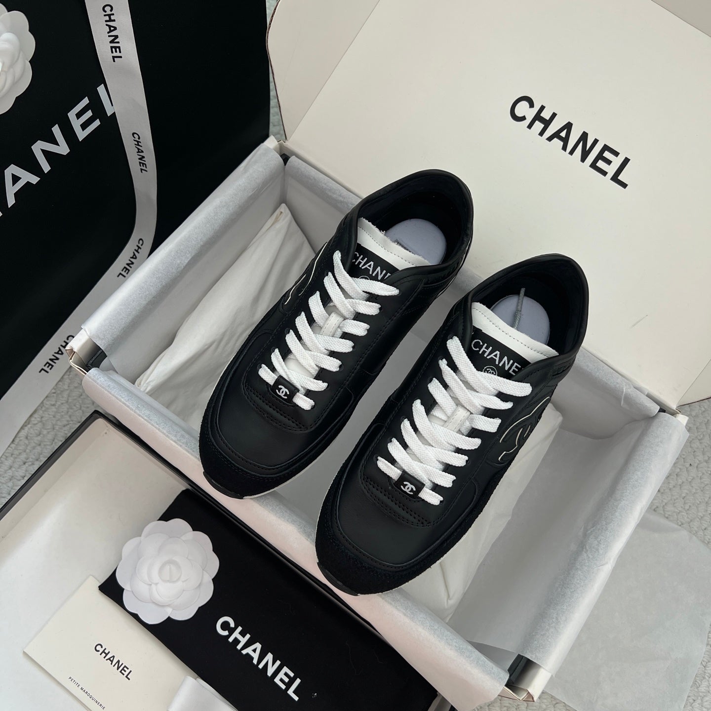 Chanel unisex black leather sneakers with white laces and logo patch