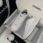 White Chanel unisex low-top sneakers in a shoe box, lace-up style.