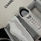 White Chanel unisex low-top sneakers with side panel stitching and lace-up.