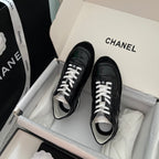 Black Chanel unisex sneakers in box with white laces and contrasting white trim