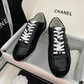 Black Chanel unisex sneakers with white laces and glossy leather uppers