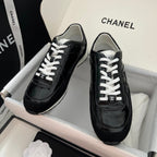 Black Chanel unisex sneakers with white laces and glossy leather uppers