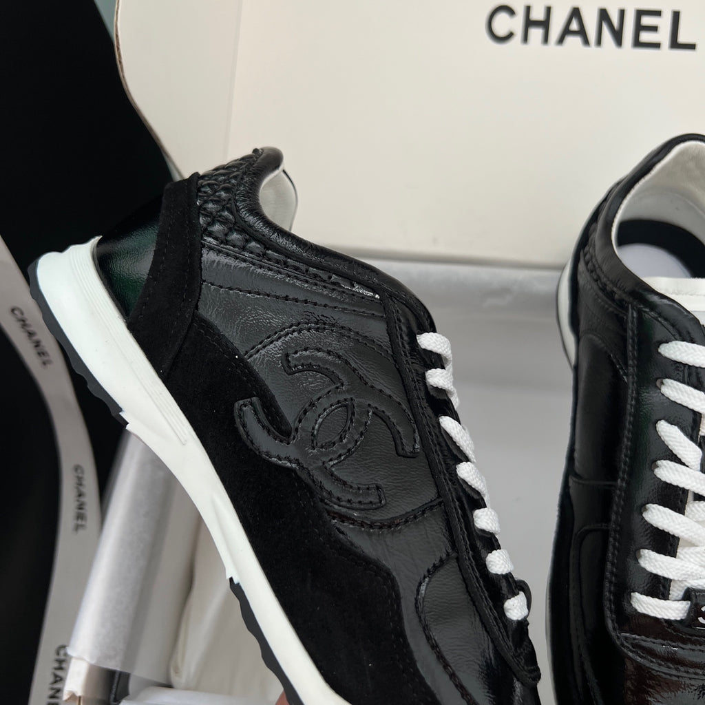 Black Chanel unisex sneaker close-up with textured side and white laces