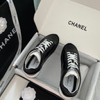 Black Chanel unisex sneakers with white laces and white rubber toe accents
