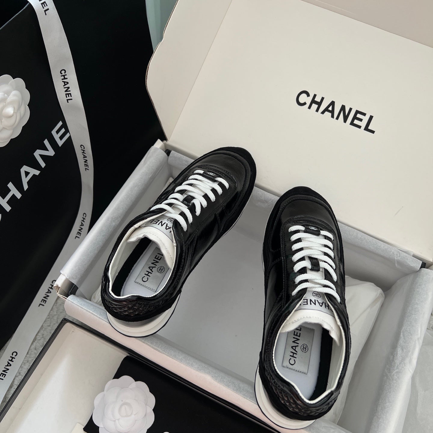 Black Chanel unisex sneakers with white laces and white rubber toe accents