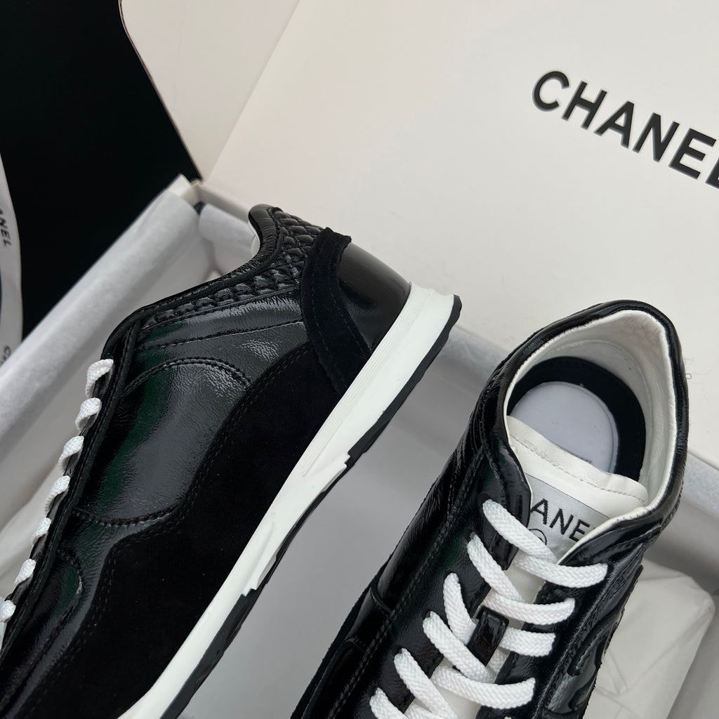 Black Chanel unisex sneakers close-up with white outsole and lace-up front