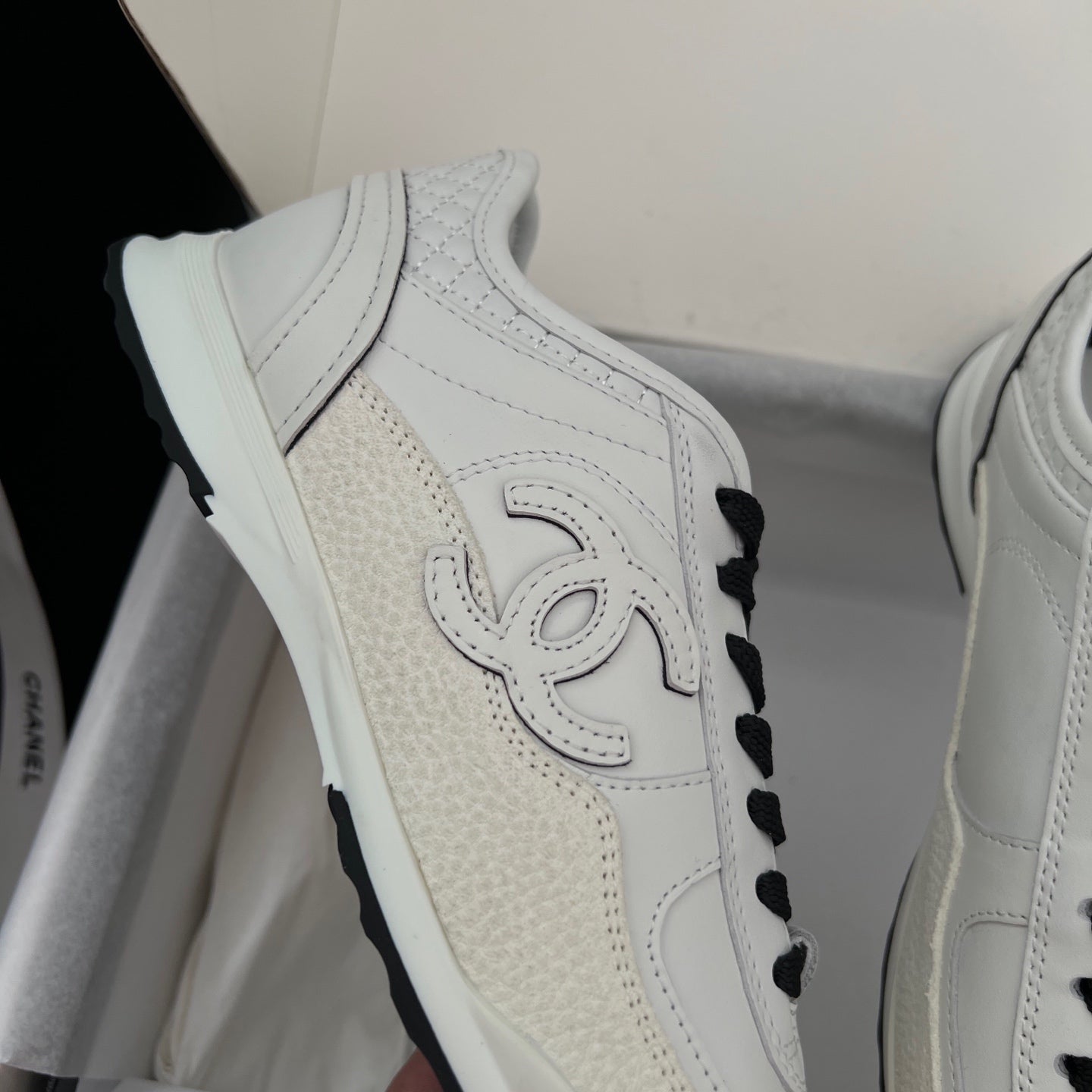 White leather sneaker with perforated panels, black laces, side Chanel emblem
