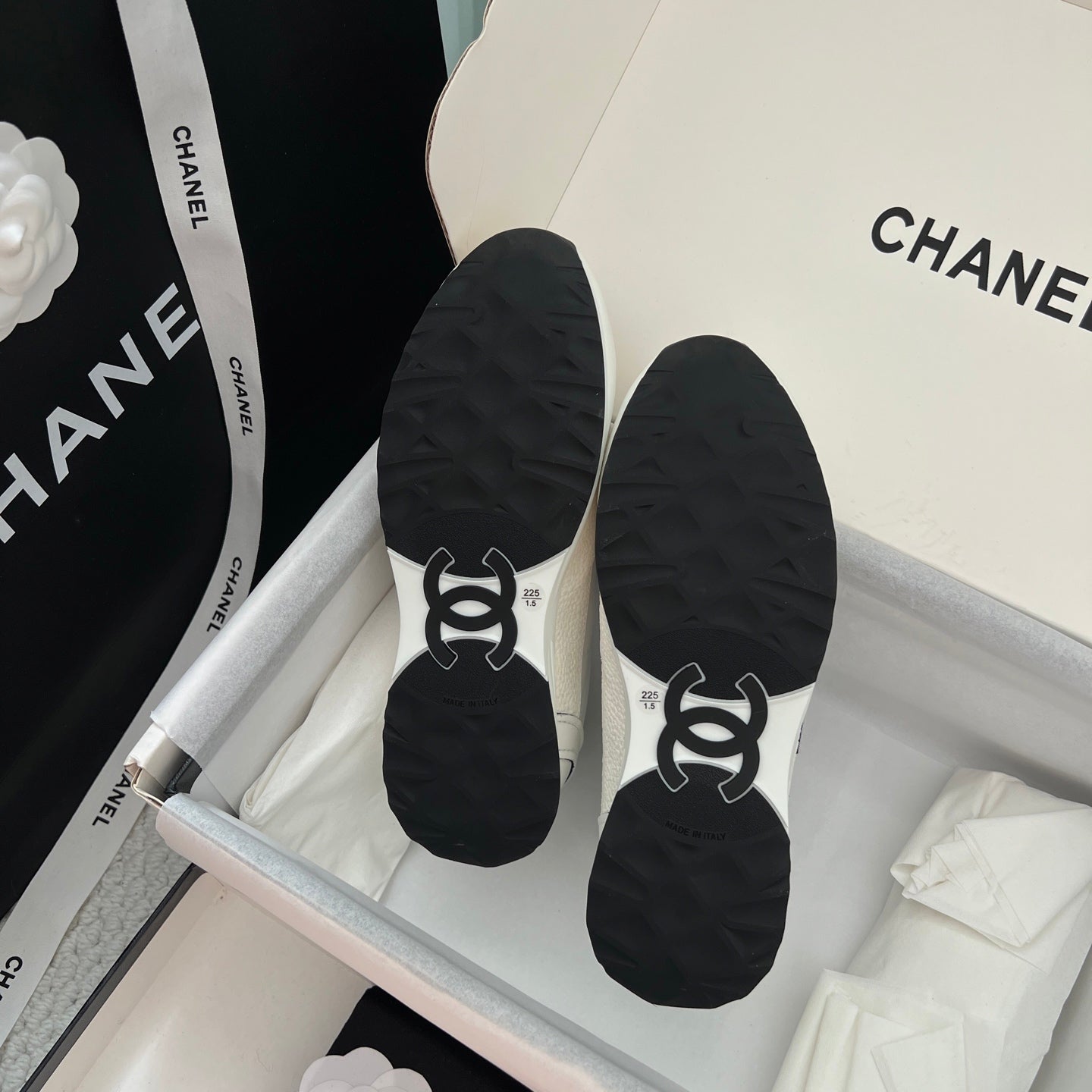 Black sneaker soles with traction tread and logo embossing