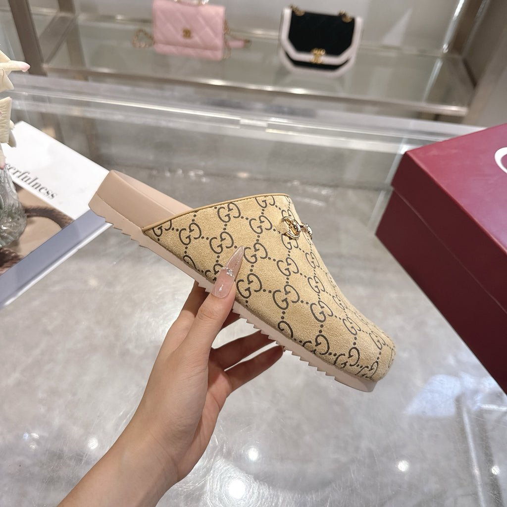 Gucci beige GG monogram slide sandal held up, showing open toe and light pink footbed