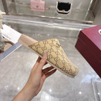 Gucci beige GG monogram slide sandal held up, showing open toe and light pink footbed