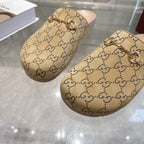 Gucci GG monogram slide sandals with gold-tone chain detail across the straps