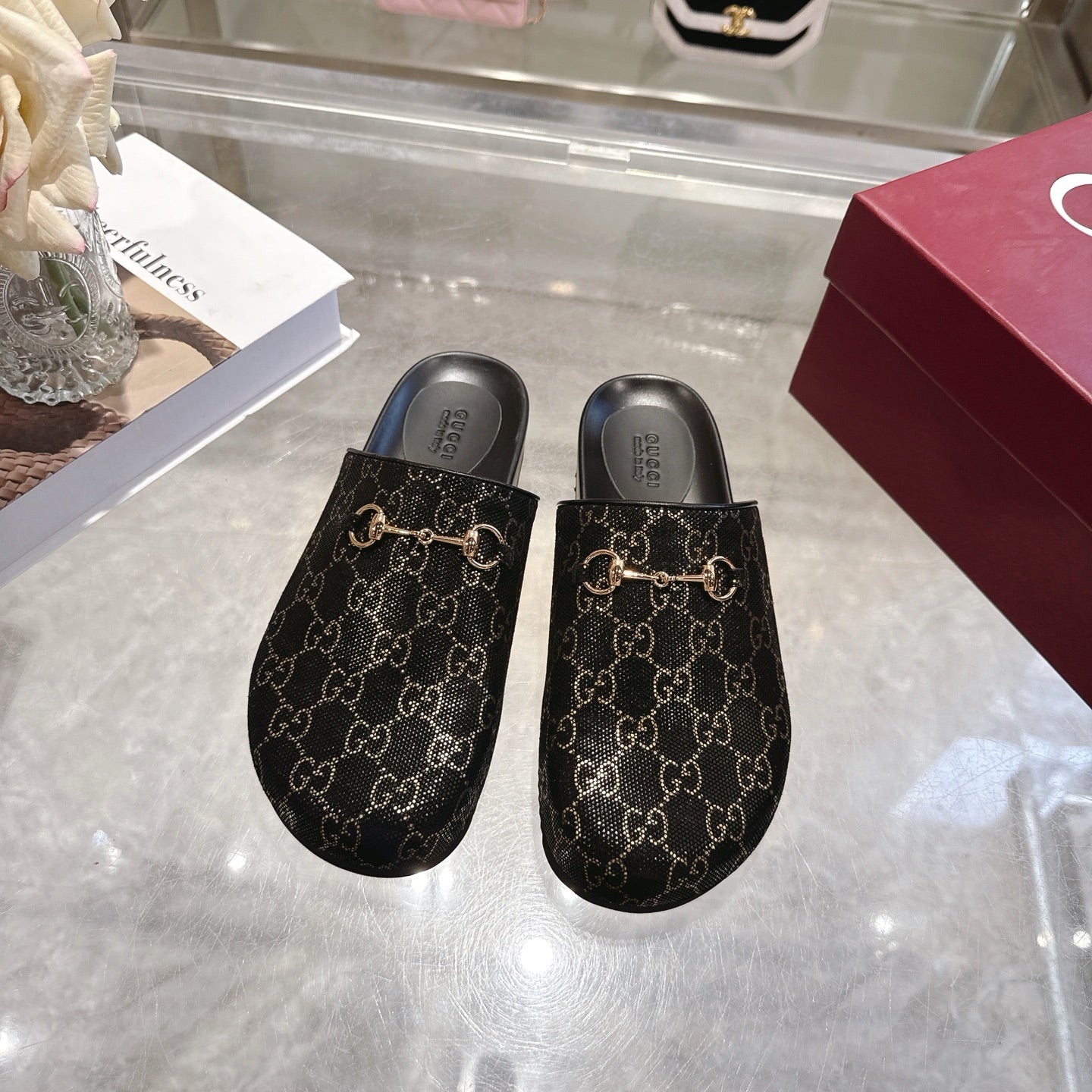 Gucci slide sandals, dark GG monogram upper with gold horsebit detail and black footbed.