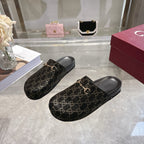 Gucci slide sandals with dark GG monogram fabric and gold horsebit detail, side-by-side view.
