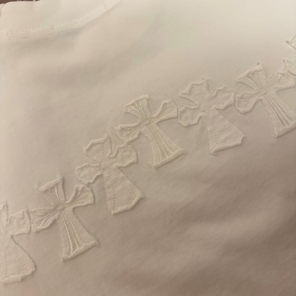 White T-shirt with row of raised embroidered cross motifs