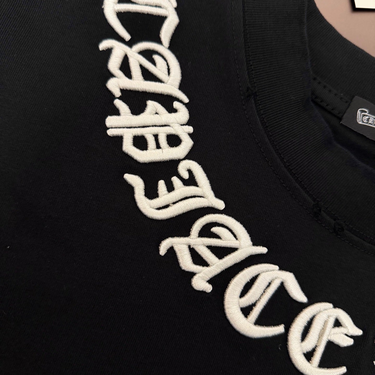 Black T-shirt close-up of white graphic lettering along the chest