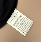 Black T-shirt care label with washing instructions and manufacturer info