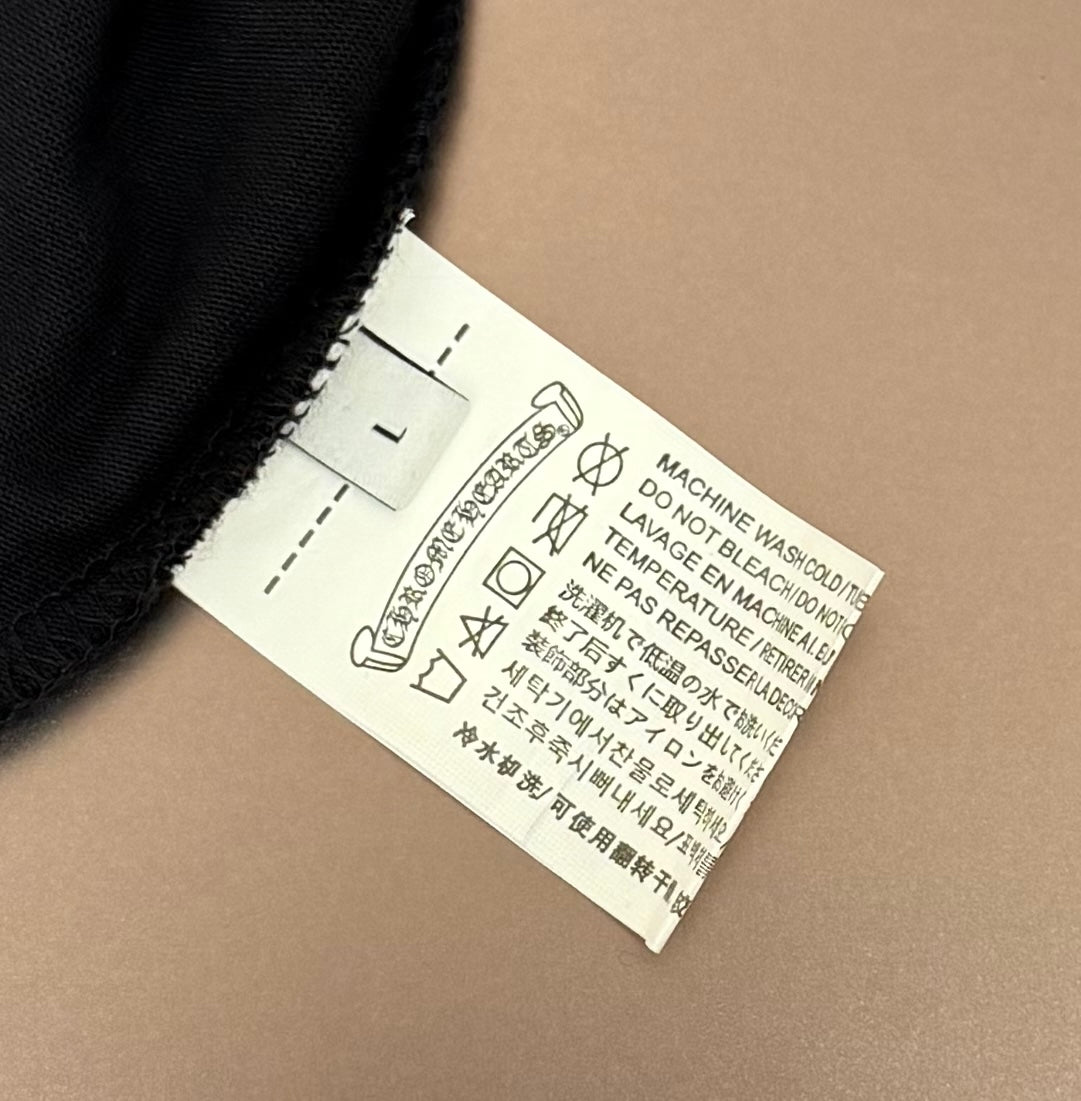 Black T-shirt care label with washing instructions and manufacturer info