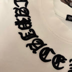 White T-shirt chest close-up with large black embroidered script