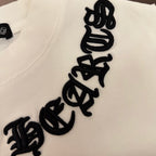 White T-shirt chest close-up with vertical black embroidered text