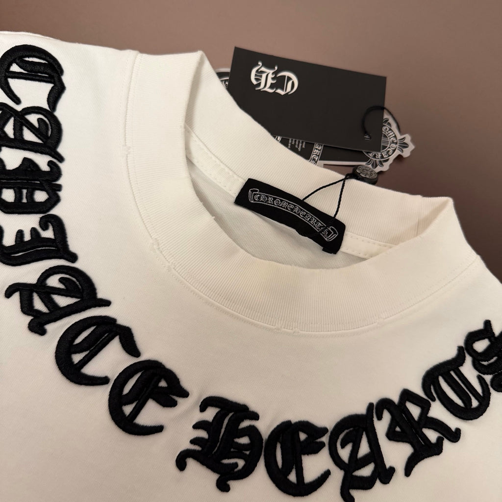 White T-shirt close-up with black stitched text across the chest