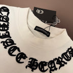 White T-shirt close-up with black stitched text across the chest
