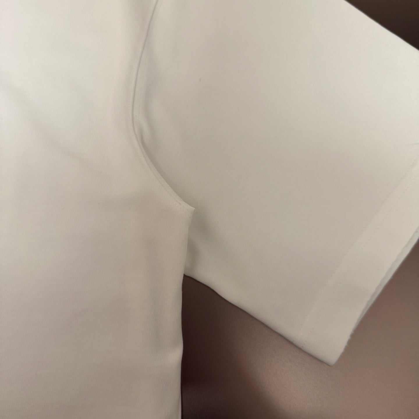 White short-sleeve T-shirt sleeve and side seam close-up