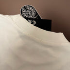 White T-shirt shoulder and neckline seam detail, with tag peeking