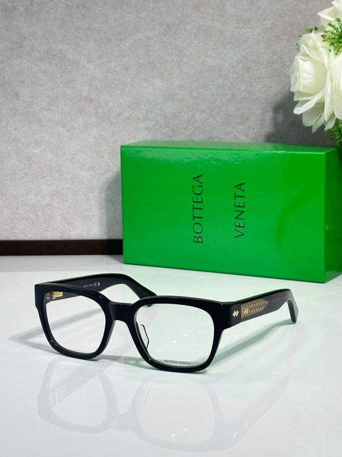 Black eyeglasses with rectangular frames and patterned gold-toned temple details