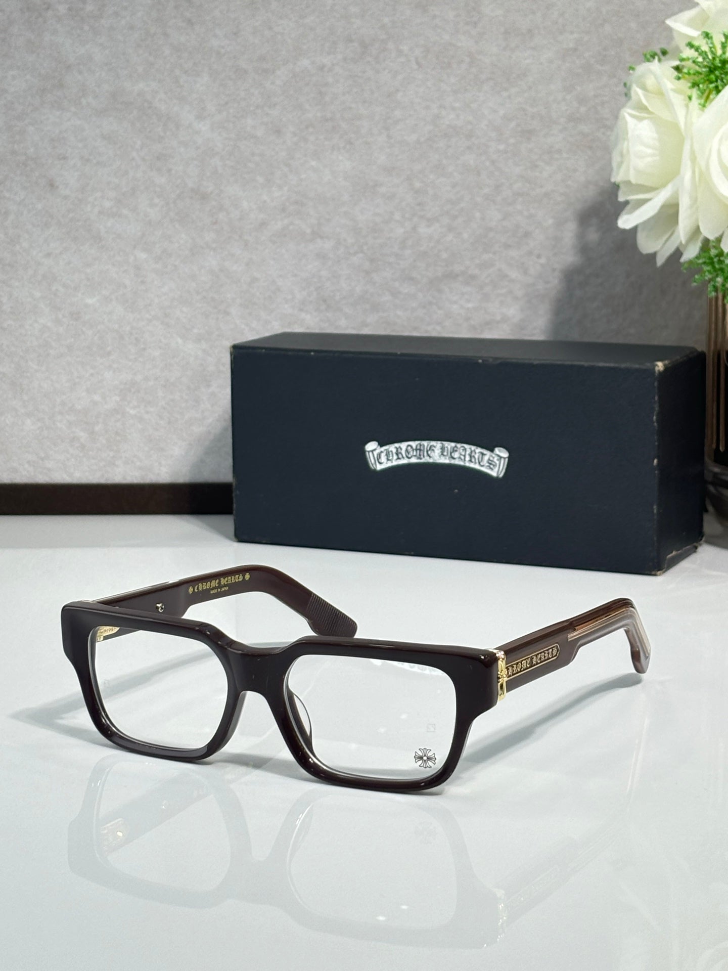 Dark brown rectangular eyeglasses with clear lenses and metal temple detailing
