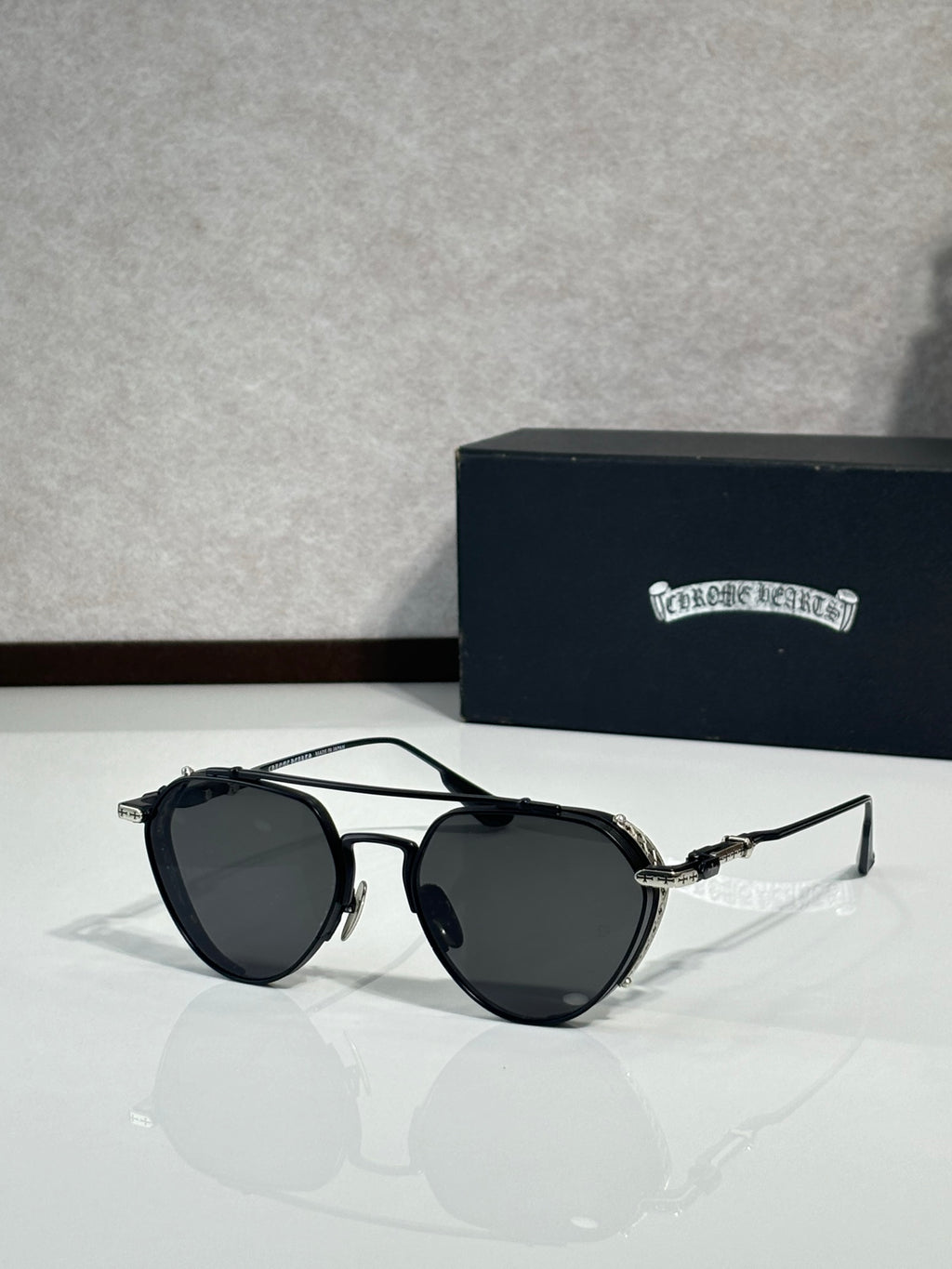 Chrome glasses with black frames and dark lenses, round oversized shape