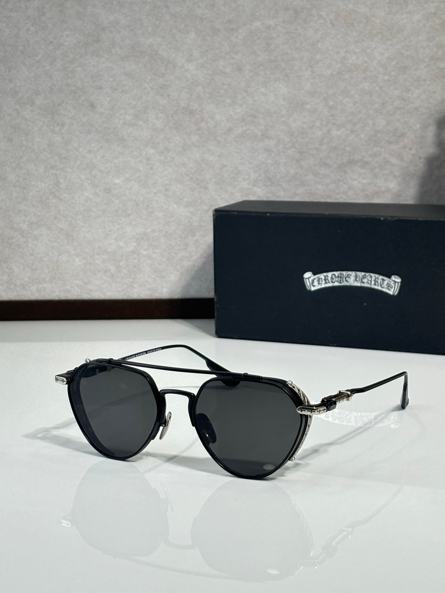 Chrome glasses with black frames and dark lenses, round oversized shape