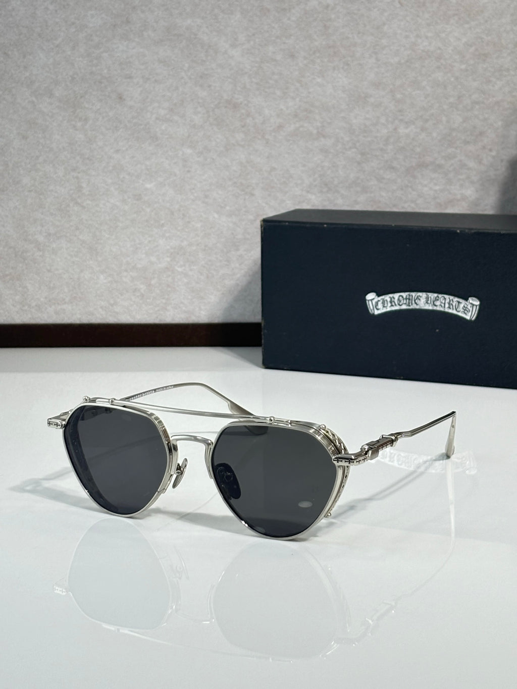 Chrome glasses with dark lenses and silver-tone metal frame, round oversized shape
