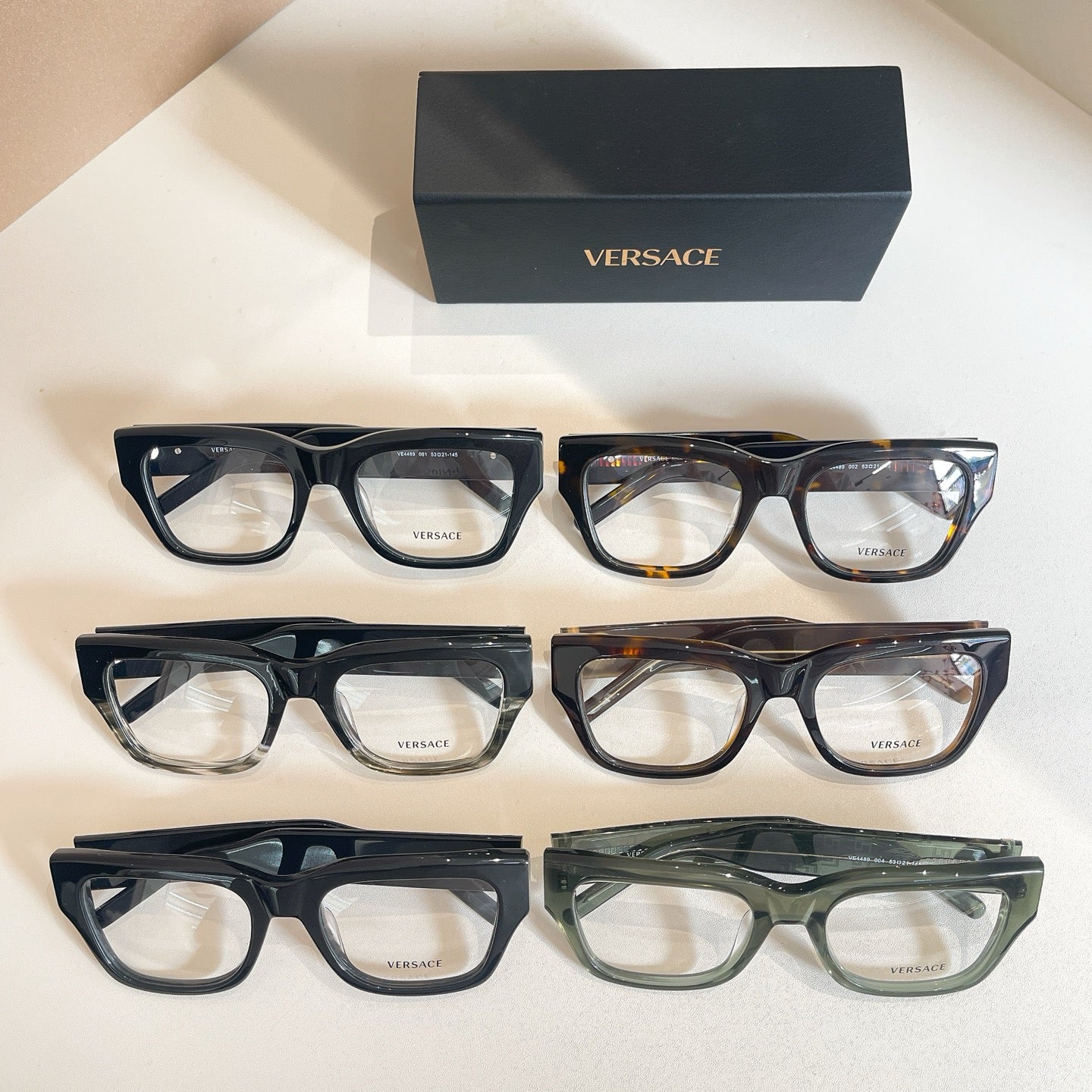 Three-pair eyeglasses set with clear lenses and patterned frames, with Versace logo box