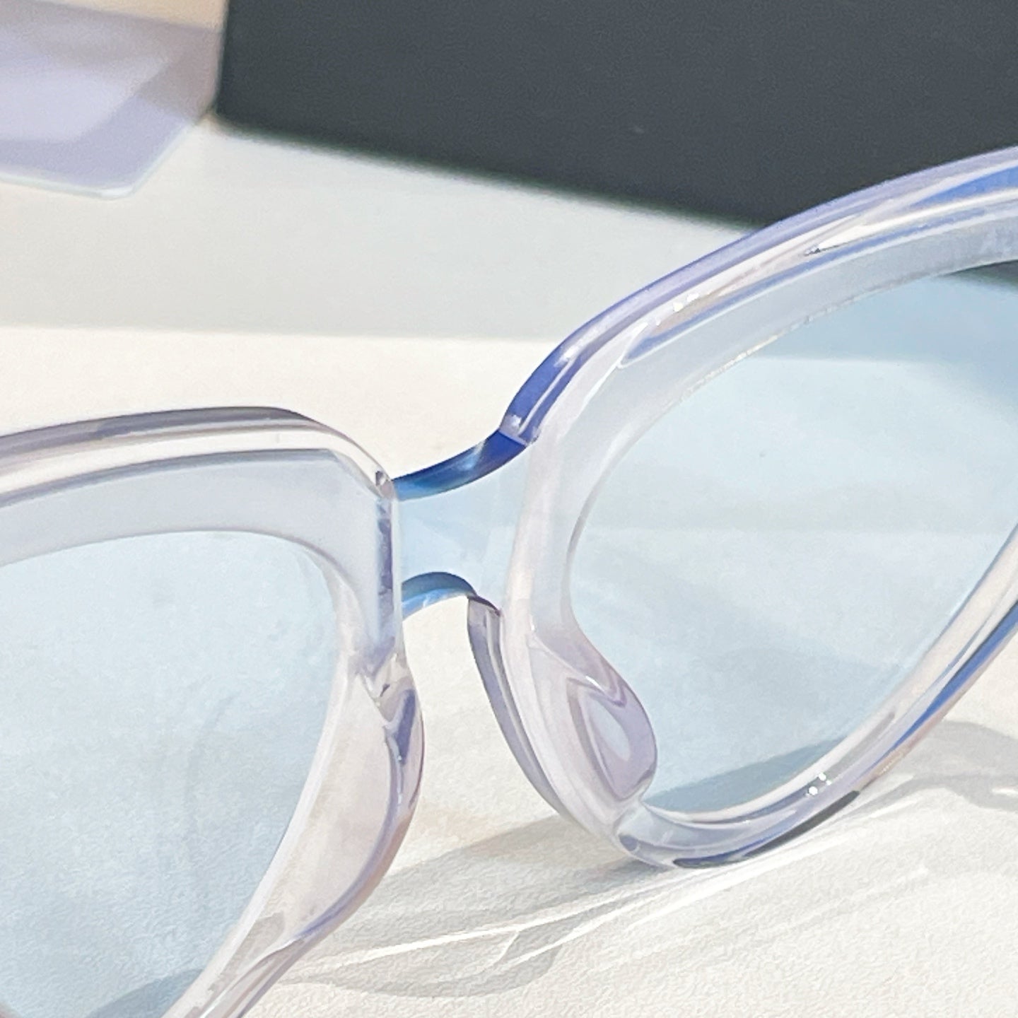 Balenciaga sunglasses close-up with clear frames and light lenses, curved temple detail