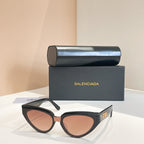 Balenciaga sunglasses with dark frames and pink-tinted lenses, gold logo temple detail