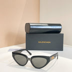 Balenciaga sunglasses with dark frames and light green lenses, gold logo on temple