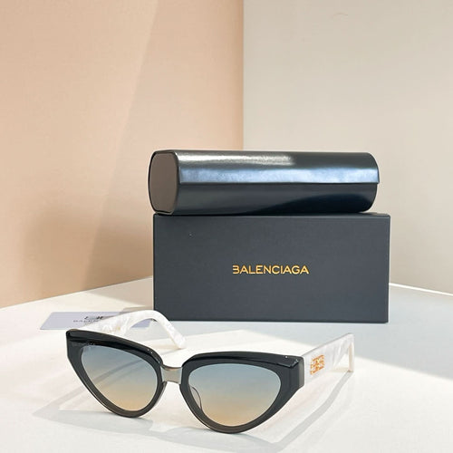 Balenciaga sunglasses with black frames and pale gradient lenses, gold logo on temple