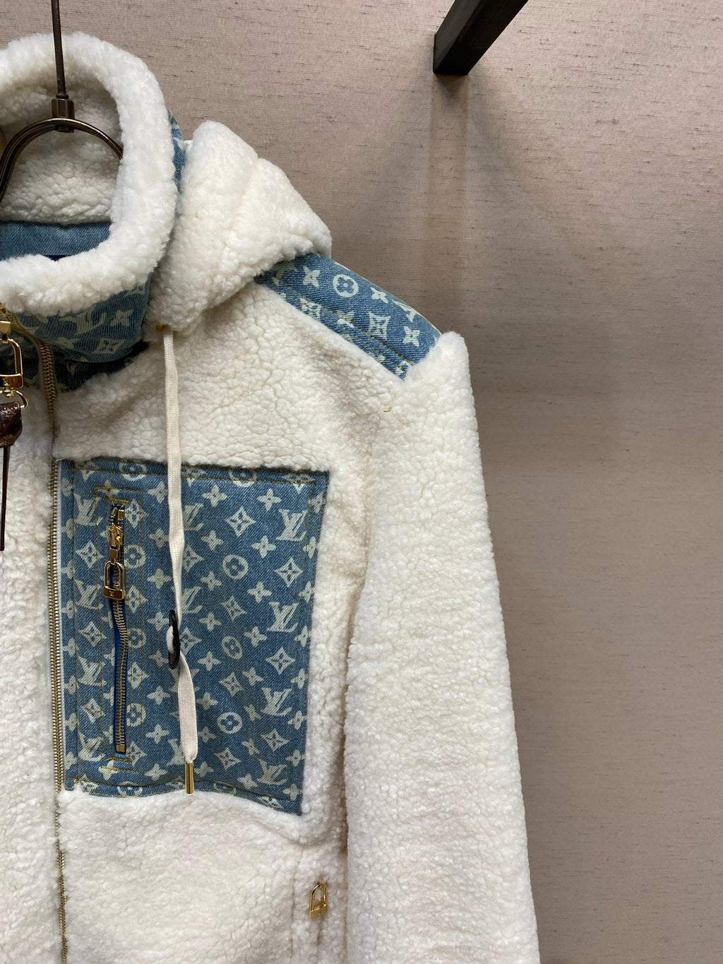 White sherpa jacket with blue monogram patch pockets and drawstring hood