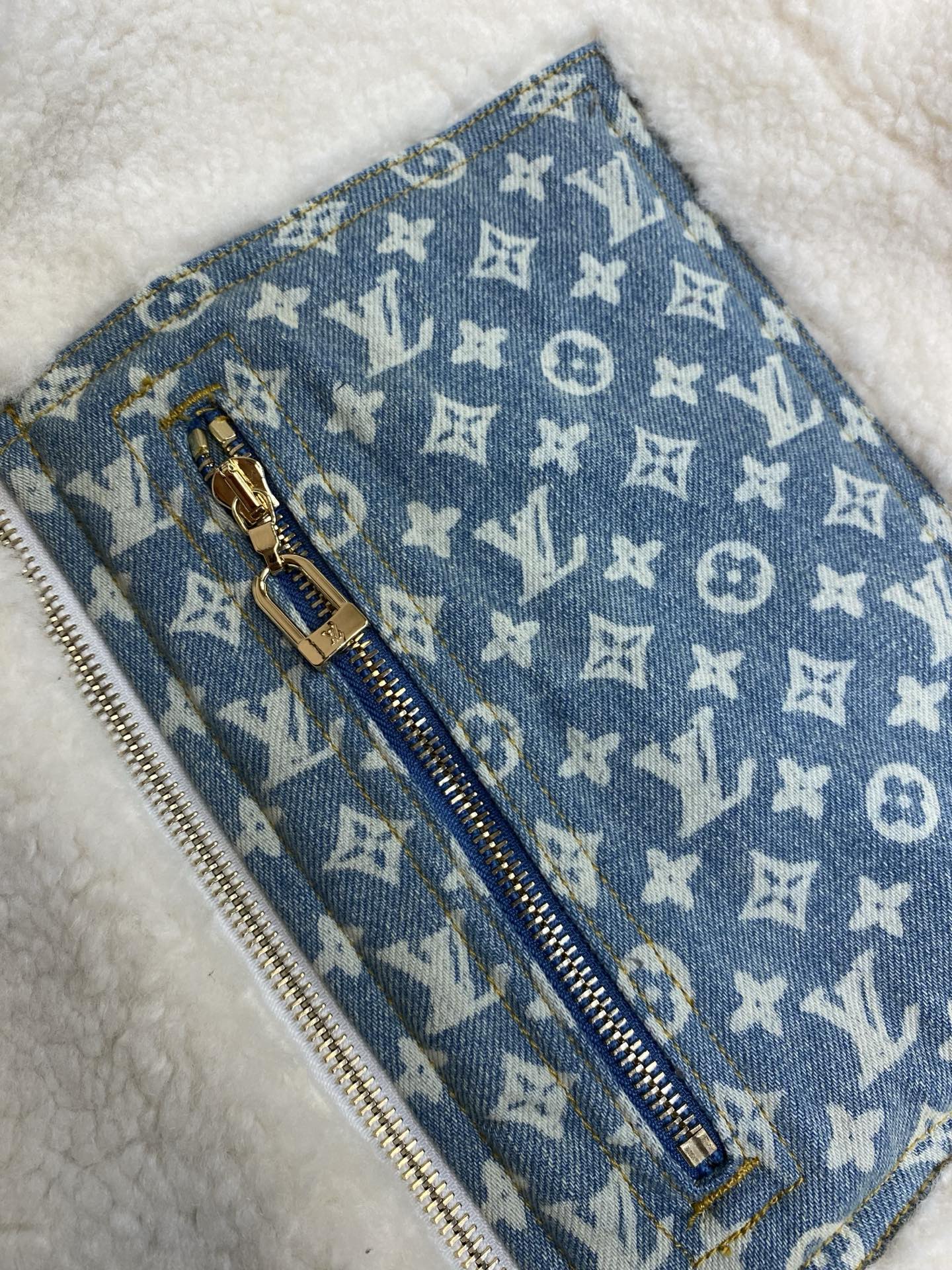 Blue monogram zip pocket panel with gold zipper on sherpa lining