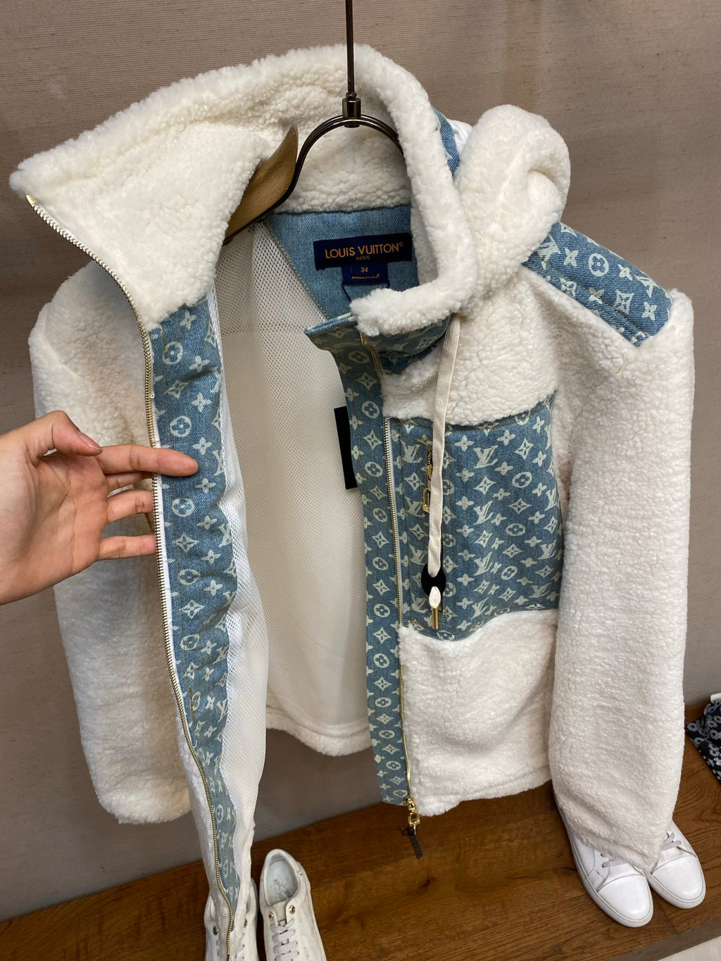 White sherpa hooded jacket with blue monogram sleeves and drawstring hood