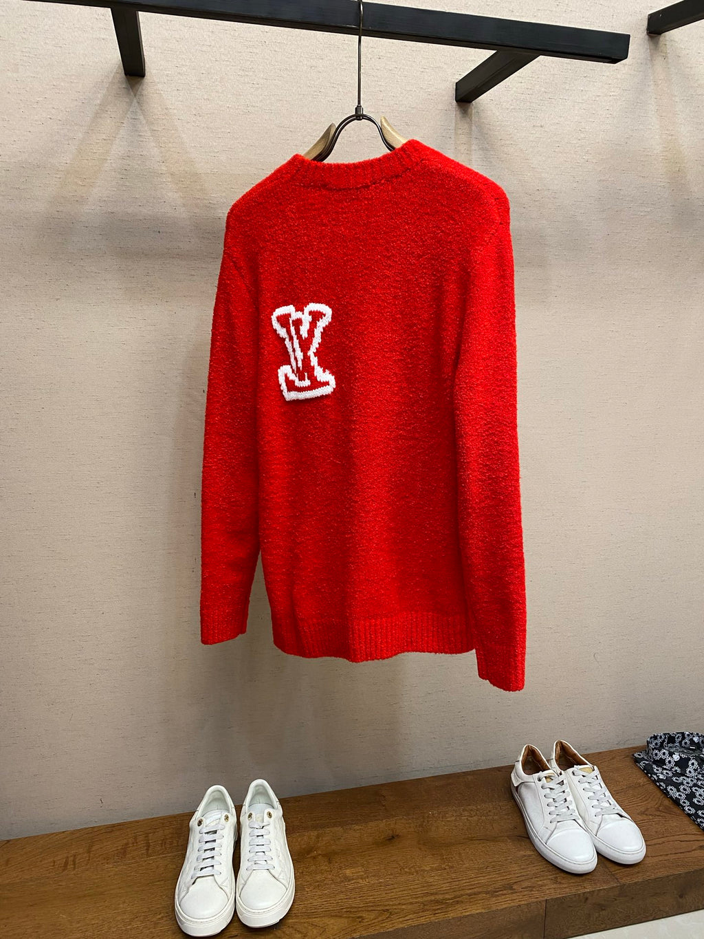 Red knit sweater with white Louis Vuitton monogram logo on the back