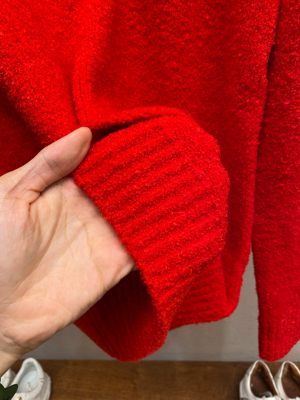 Red knit sweater sleeve with ribbed cuff texture