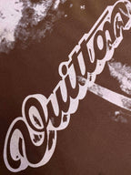 Louis Vuitton short-sleeve T-shirt fabric close-up with large white script print on dark brown