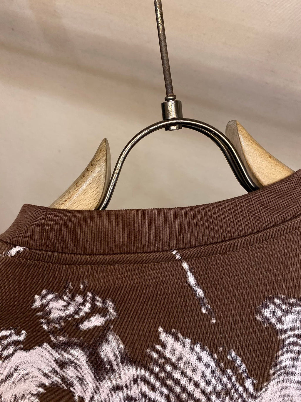 Louis Vuitton T-shirt collar close-up with white splatter print on dark brown