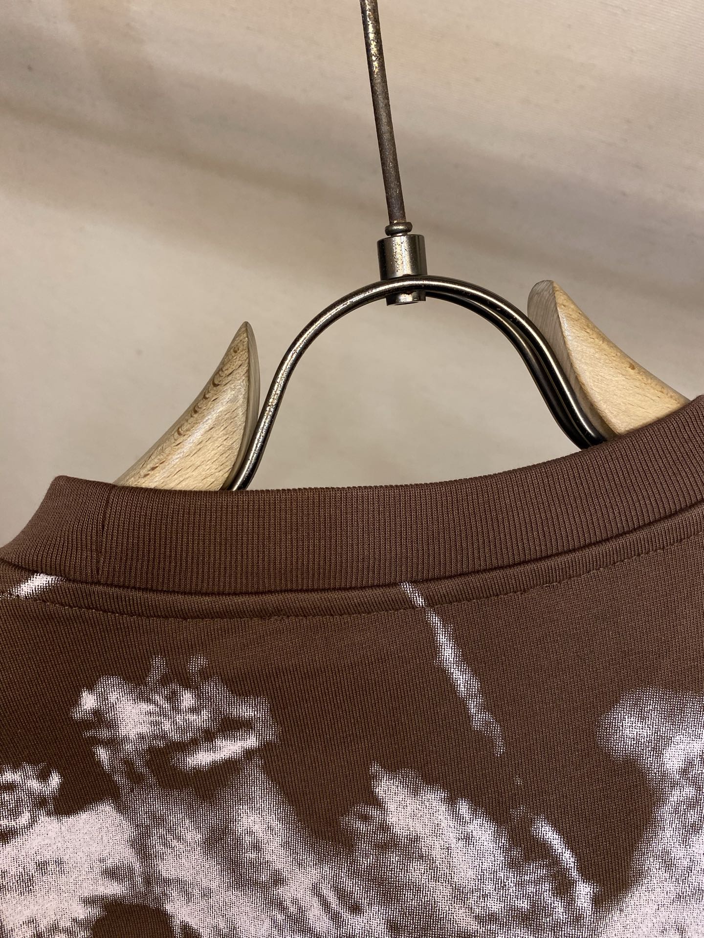 Louis Vuitton T-shirt collar close-up with white splatter print on dark brown