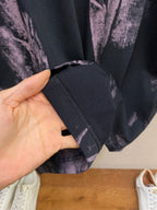 T-shirt sleeve hem detail in dark fabric with purple splatter print