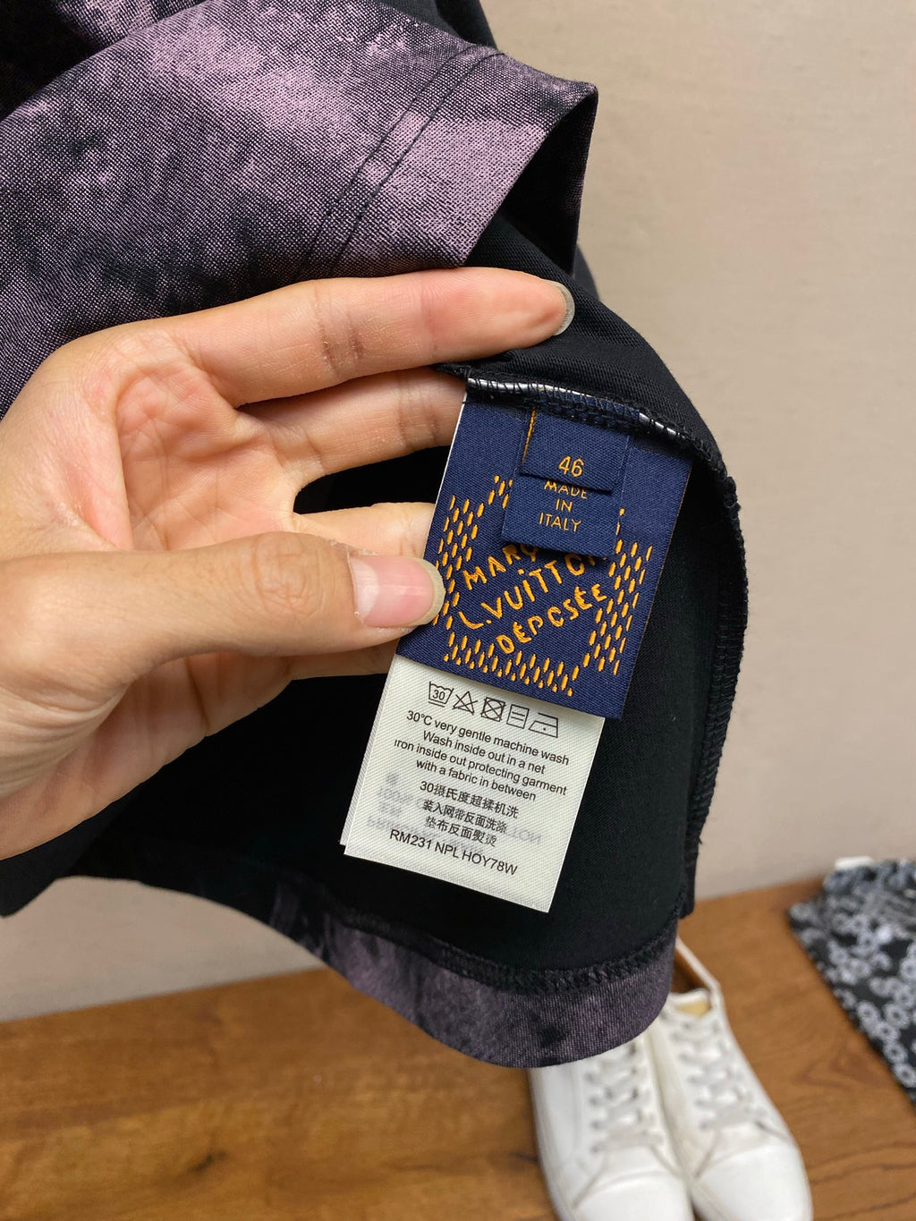 Inside neck care label on dark T-shirt with purple splatter fabric