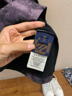 Inside neck care label on dark T-shirt with purple splatter fabric
